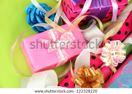 Rolls of Christmas wrapping paper with ribbons, bows on color background