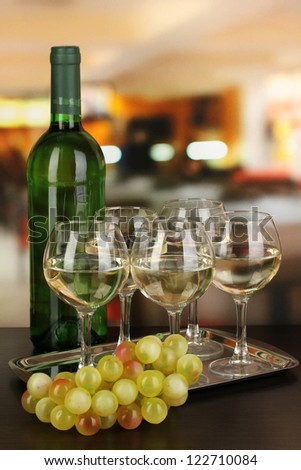 White wine in glass and bottle on room background