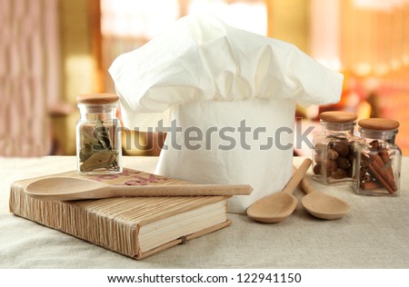 Chef\'s hat with spoons on table in kitchen