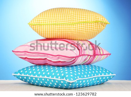 Pink, yellow and blue bright pillows on blue background
