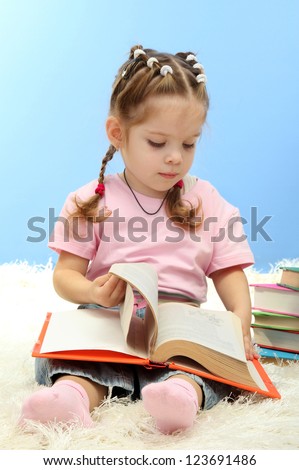 cute little girl with colorful books, on blue background