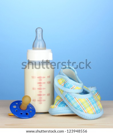 Baby bottle of milk on blue background