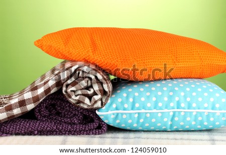 Plaids and color pillows on green background