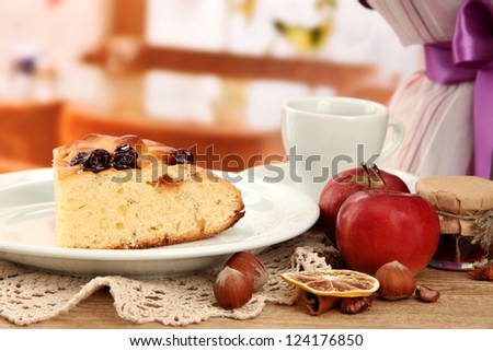 slice of tasty homemade pie with jam and apples, on wooden table in cafe