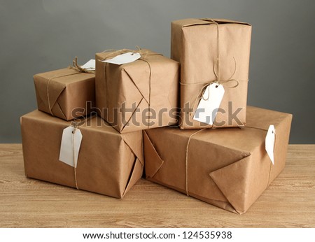 parcels boxes with kraft paper, on wooden table on grey background