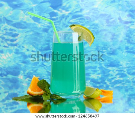 Glass of blue cocktail on blue background