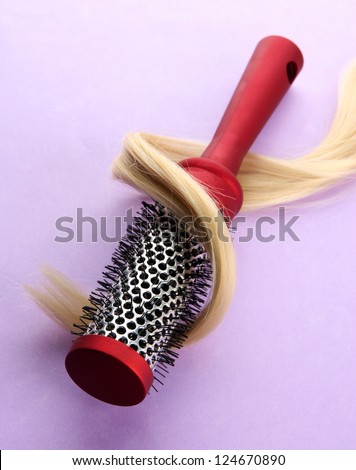 comb brush with hair,  on purple background