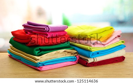 heap of cloth fabrics on wooden table