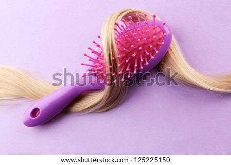 comb brush with hair,  on purple background