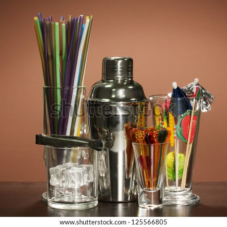 Cocktail shaker and  other bartender equipment on color background