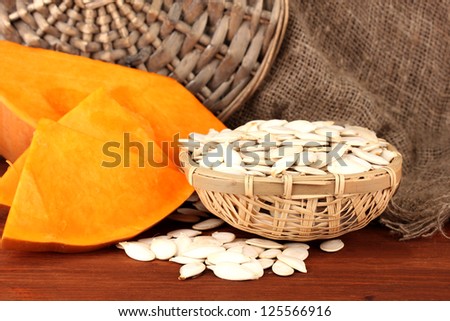 Pumpkin seeds in wicker box, on sackcloth background