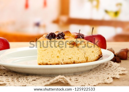 slice of tasty homemade pie with jam and apples, on wooden table in cafe