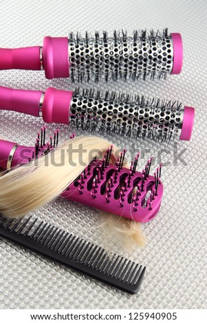 Comb brushes with hair, on grey background