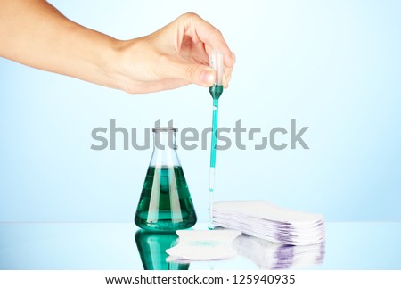 Testing sanitary pads for absorbency, on blue background close-up