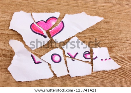 Torn paper with words Love close-up on wooden table