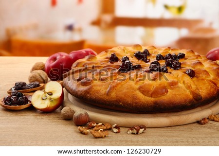 tasty homemade pie with jam and apples, on wooden table in cafe