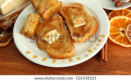 White bread toast with honey and cup of coffee on wooden table