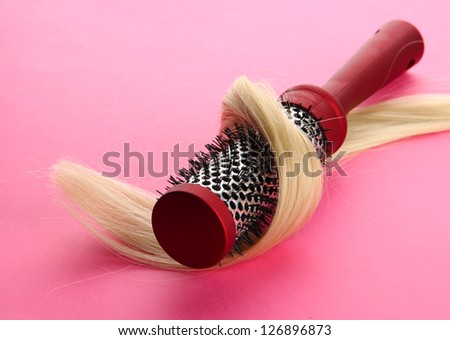 comb brush with hair,  on pink background