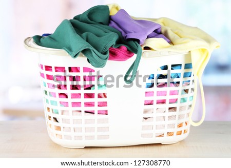 Clothes in plastic basket on table in room