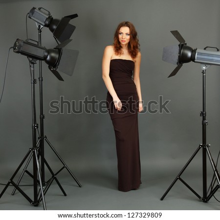 Beautiful professional female model resting between shots in photography studio shoot set-up