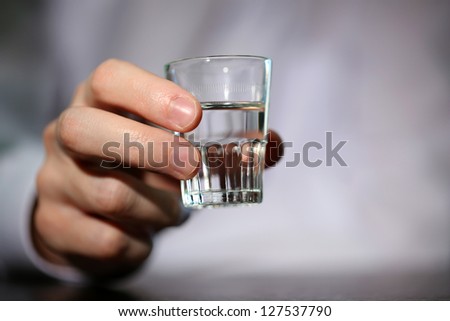 Man hand with glass of vodka , close up