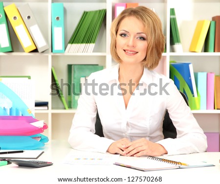 Young beautiful business woman in office at her workplace