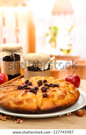 tasty homemade pie with jam and apples, on wooden table in cafe