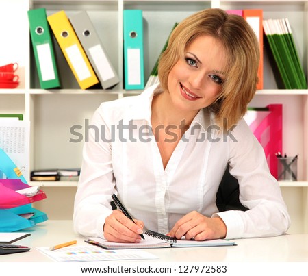 Beautiful young business woman working in office