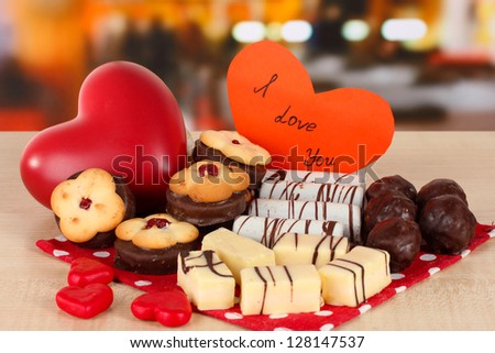 Sweet cookies with hearts and valentine card on table in cafe