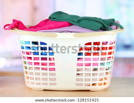 Clothes in plastic basket on table in room