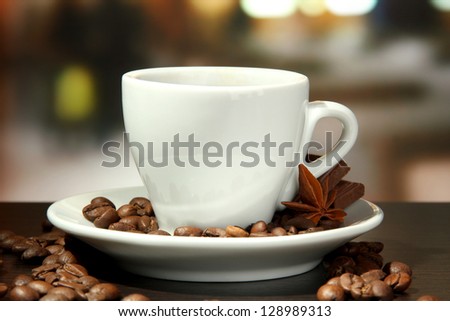cup of coffee with beans on table in cafe