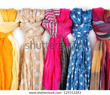 Many bright female scarfs close-up