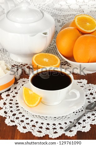Beautiful white dinner service with oranges on wooden table close-up