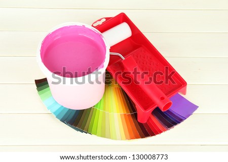 Set for painting: paint pot, paint-roller on white wooden table
