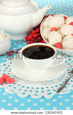Beautiful white dinner service with an air meringues on blue tablecloth close-up