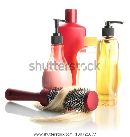 comb brush with hair and cosmetic bottles, isolated on white