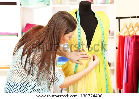 Beautiful young dressmaker in workroom