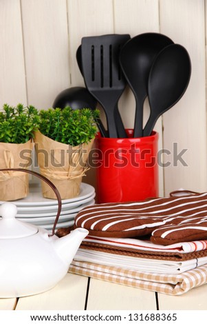 Kitchen settings: utensil, potholders, towels and else  on wooden table