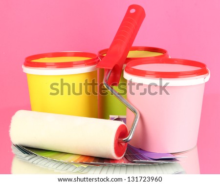 Set for painting: paint pots, paint-roller, palette of colors on pink background