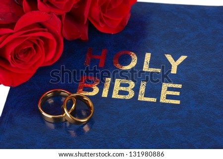 Wedding rings with roses on bible