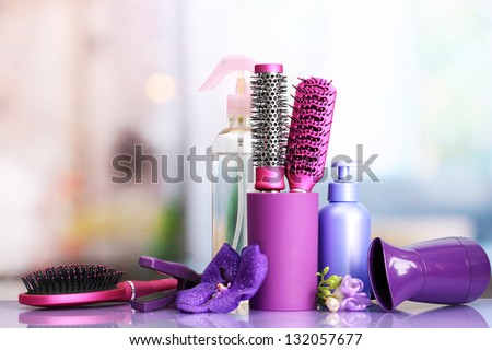 Hair brushes, hairdryer, straighteners and cosmetic bottles in beauty salon