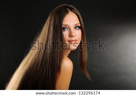 Portrait of beautiful woman with long hair on black background