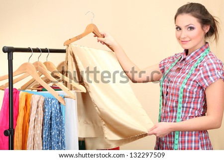 Beautiful young dressmaker chooses fabric for future dress