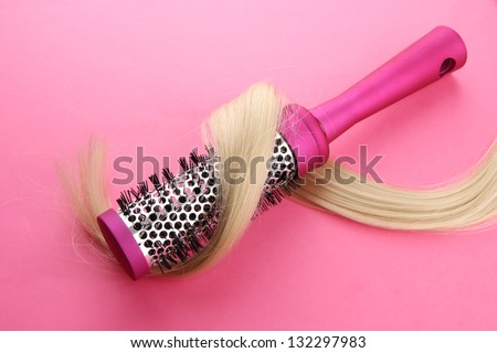 Comb brush with hair,  on pink background