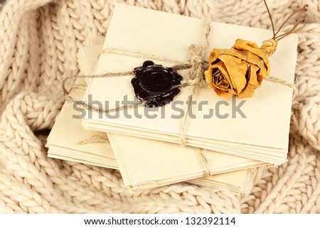 Stacks of old letters with dried rose on soft scarf