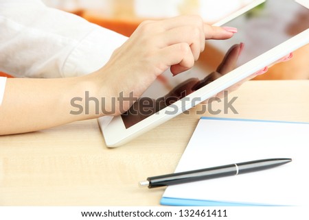 Female office worker using digital tablet in cafe