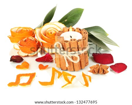 Decorative rose from dry orange peel and burning candle isolated on white