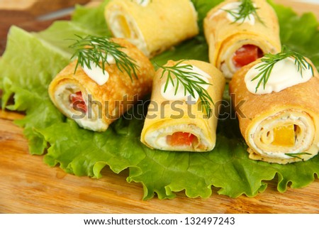 Egg rolls with cheese cream and paprika, on wooden board, close up
