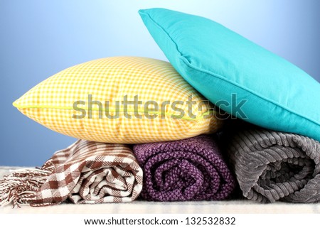 Plaids and color pillows on blue background