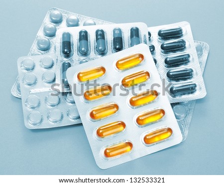 Capsules and pills packed in blisters in grey light